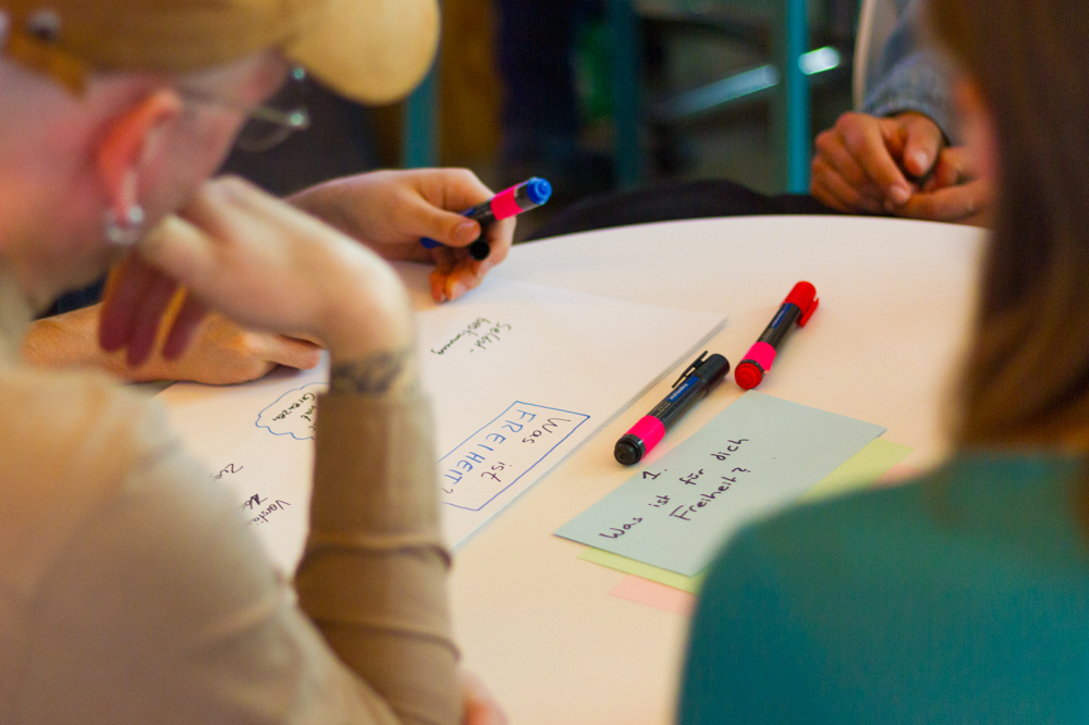 Zettel auf Tisch mit Aufschrift "Was ist für dich Freiheit"